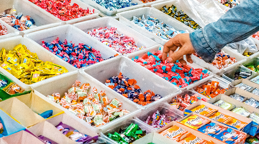 The Tell-Tale Cavity: Five Foods to Avoid This Holiday Season, image of candy and a person shopping