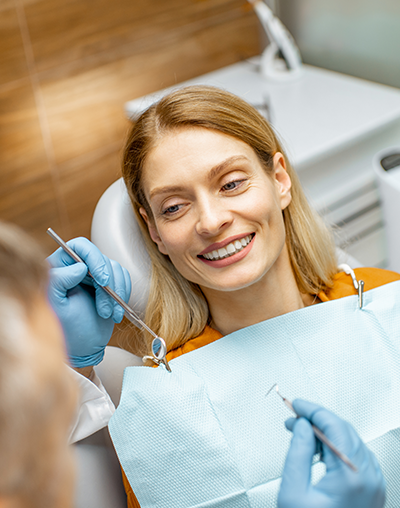 Dental Cleaning, image of a woman in the dental chair smiling after a cleaning.
