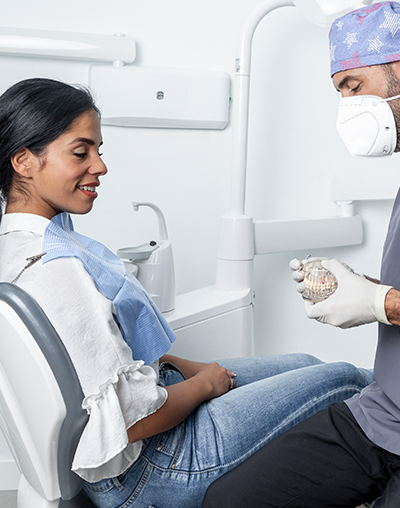 Dental Crowns, image of a dentist showing a patient a crown replacement