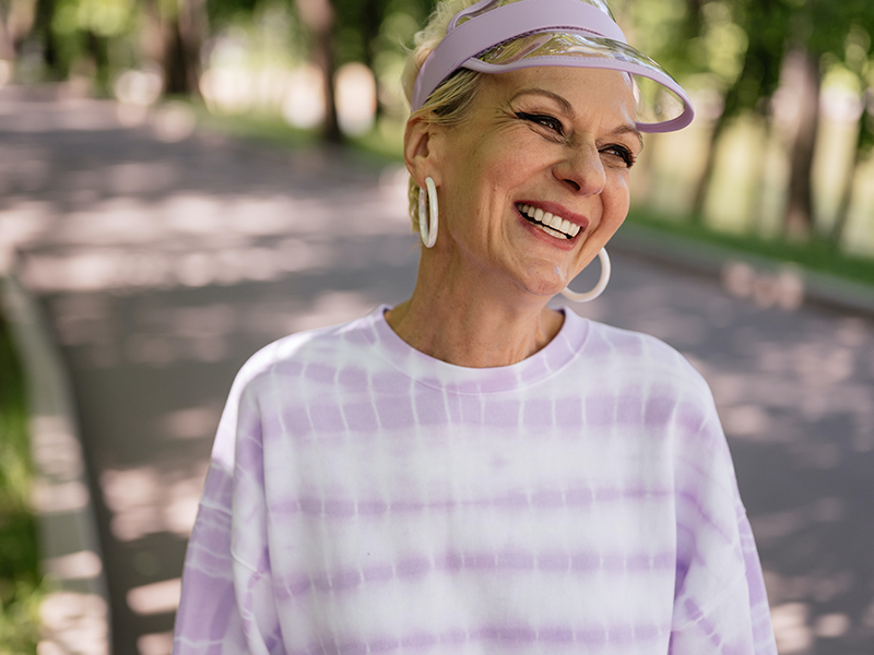 dental-services-Restorative Dentistry, image of an older woman smiling while walking outside.