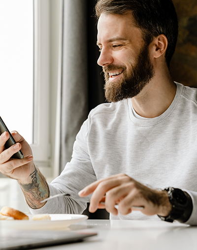 Inlays/Onlays, image of a bearded man smiling while looking at his phone