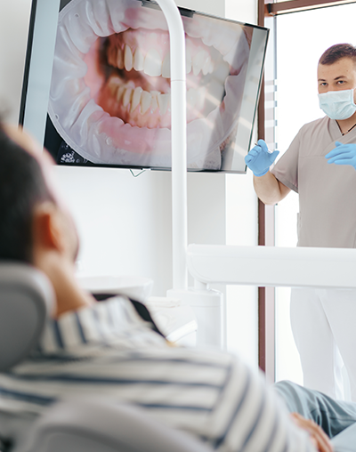 Oral Cancer Screening, image of a dentist showing a patient their oral screening results.