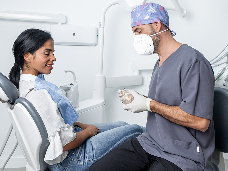 dental-services, Dental Crowns, image of a dentist showing a patient a crown replacement
