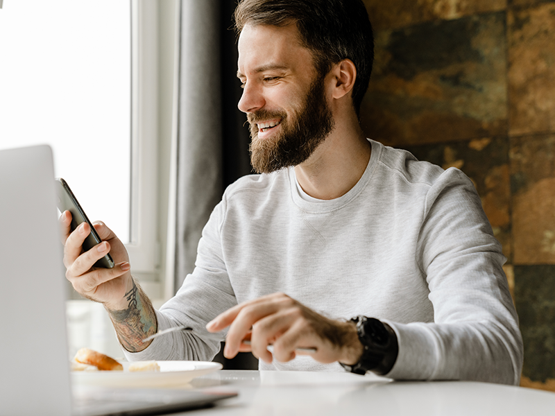 dental-services, Inlays/Onlays, image of a bearded man smiling while looking at his phone